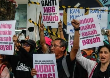 Massa aksi mengangkat poster tuntutan audit MBG dan kritik kondisi hidup saat demo di depan kantor BGN Jakarta