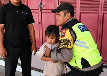 Polsek Keling menggendong bocah 4 tahun yang sempat terlantar di dekat SPBU Sambungoyot, Jepara, sebelum dipulangkan kepada keluarganya.