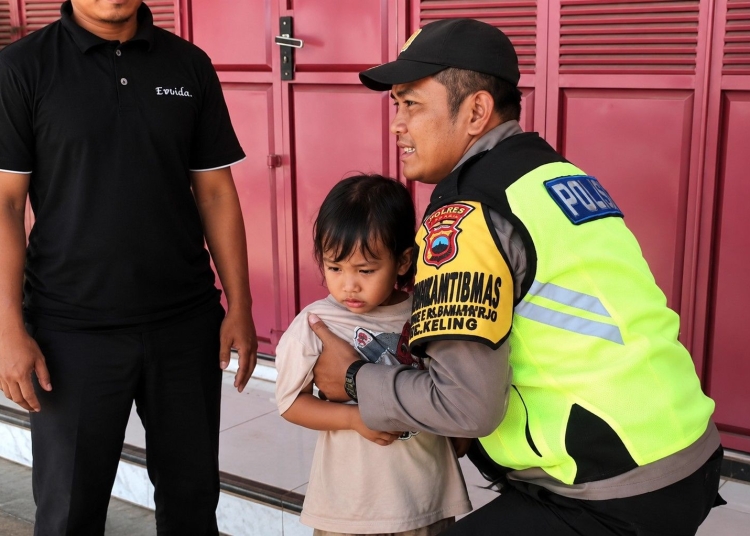Polsek Keling menggendong bocah 4 tahun yang sempat terlantar di dekat SPBU Sambungoyot, Jepara, sebelum dipulangkan kepada keluarganya.