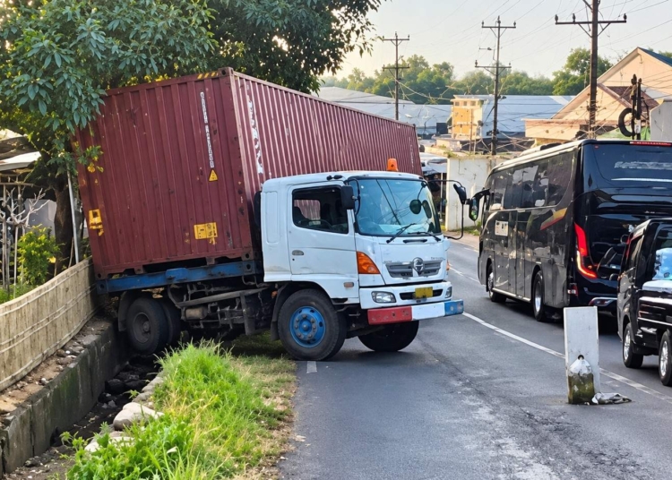 Truk kontainer terperosok ke saluran air di Tanjakan Mantingan Jepara setelah gagal menanjak menuju arah Ngabuk, Jumat sore 16 Oktober 2026.